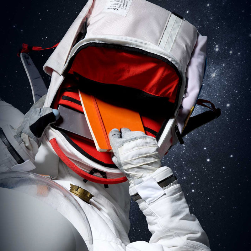 s pace backpack open with an astronaugt pulling out a notebook